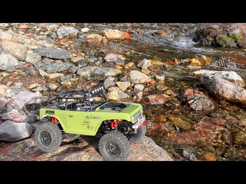 Axial scx24 deadbolt rock crawling next to creek
