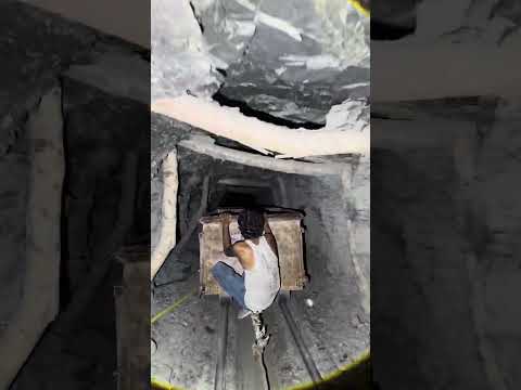 Workers extract coal from a cart inside a 3,000-foot-long mine.